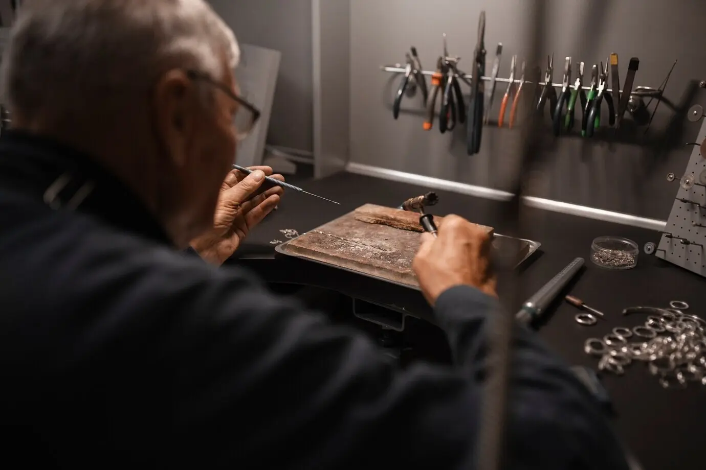 A jeweler at work in the shop with equipment.